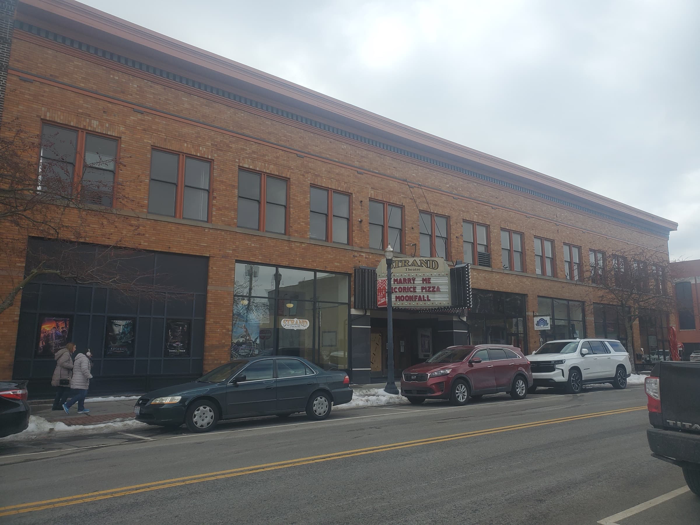 The Strand Theatre's brick facade and lit marquee in downtown Delaware